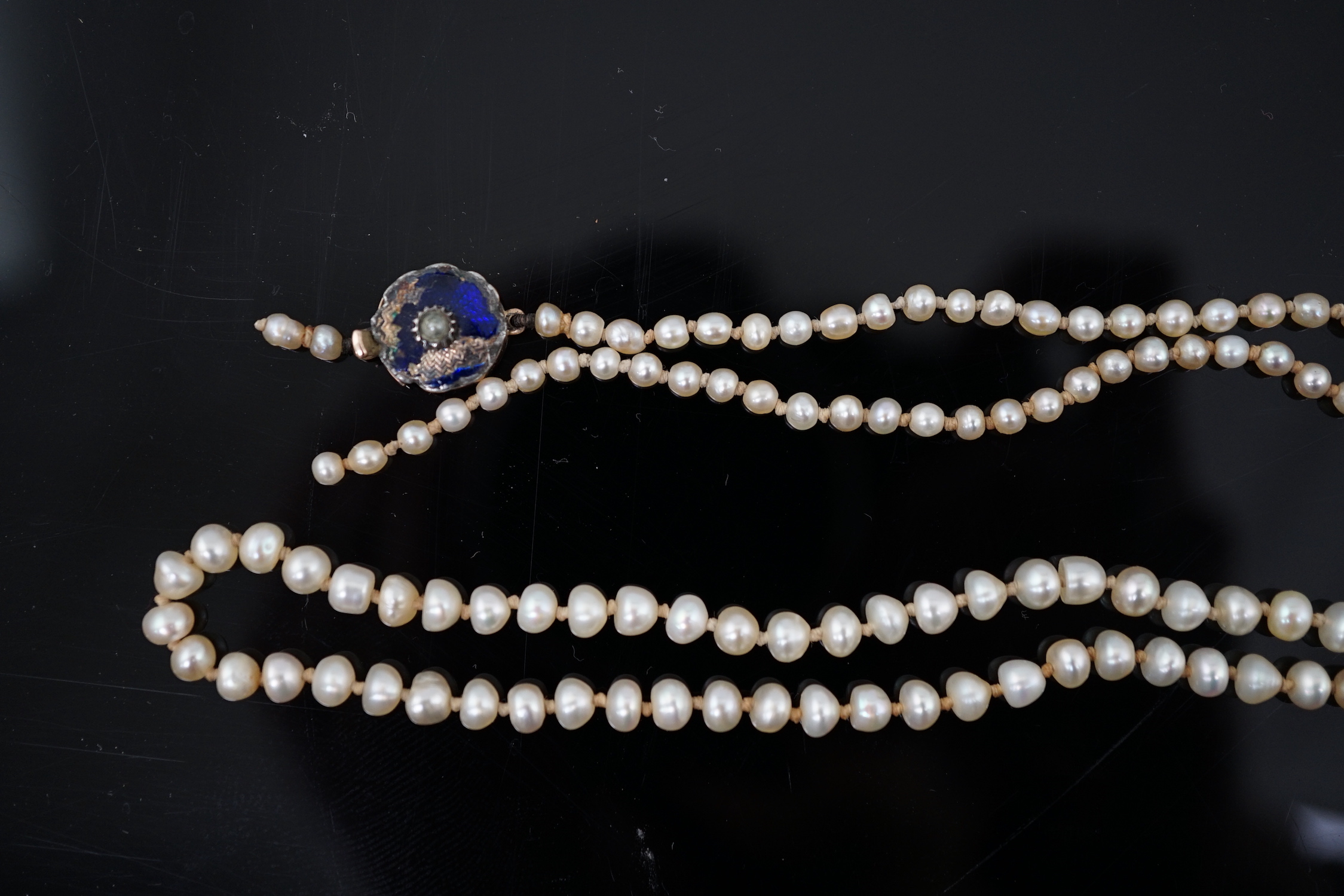 A Victorian single strand graduated natural saltwater pearl necklace, with seed pearl and enamel set gold clasp
